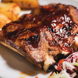 Costine di maiale in salsa BBQ con patate al forno