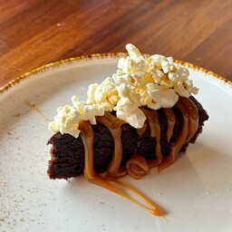 Caprese al cioccolato con caramello salato, scaglie di cocco e pop corn