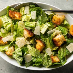 Caesar Salad con pollo, parmigiano, crostini di pane e salsa caesar.